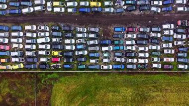 Eski arabalar kırsal alanda toprak bir yolda dizilmişler. Araçlar farklı koşullarda ve renk kalıplarında, yakınlarda çimenlik bir alan var..