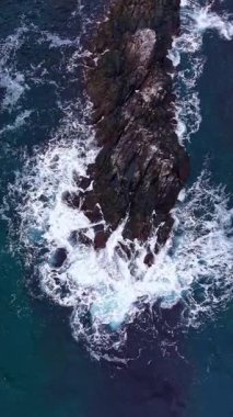 Okyanus, dalgaların engebeli kayalara çarpmasıyla mavileşir. Kıyı şeridinde parlak, güneşli bir günde köpüklü beyaz sprey püskürterek çarpıcı bir sahil manzarası yaratır..