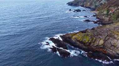 Dalgalar kayalık sahilde usulca yuvarlanırken sabahın erken saatlerinde manzara üzerinde yumuşak bir parıltı oluşuyor. Deniz kuşları huzurlu suların üzerinde süzülerek sakin bir atmosfer yaratırlar..