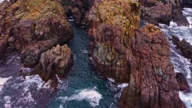 Dalgaların kayalara çarptığı türkuaz sulardan yükselen engebeli uçurumlar, sakin bir sahil ortamında doğanın gücünü ve güzelliğini gözler önüne seriyor..