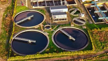 Havadan bakıldığında geniş dairesel tankları, çalışan makineleri ve çevresini çevreleyen yeşilliği olan gelişmiş bir atık su arıtma tesisi ortaya çıkıyor..