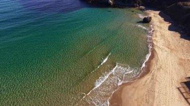 Güneş ışığı suyun üzerinde parıldarken dalgalar yavaşça kıyıya vurur ve sabahın erken saatlerinde el değmemiş bir sahilde sakin bir manzara yaratır. Yumuşak kumlar misafirleri rahatlamaları için davet eder.