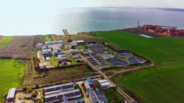 Geniş bir su arıtma tesisi, yemyeşil alanlar ve sakin bir rıhtımla çevrili gelişmiş sistemler sergiliyor. Doğa ve endüstrinin karışımı önemli çevresel çabaları vurguluyor.