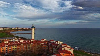Renkli binalarla çevrili sakin deniz sularına bakan uzun bir deniz feneriyle büyüleyici bir manzara gözler önüne seriliyor. Akşam yaklaşırken gökyüzü mavi ve gri yumuşak renklerle değişiyor..