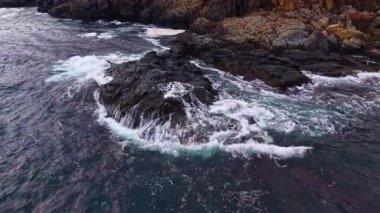 Dalgalar yavaşça yuvarlanır, güneş ufukta batarken, dalgalar, parıldayan suyun üzerine sıcak bir parıltı saçarak, huzurlu bir sahil kaçışı yaratır..