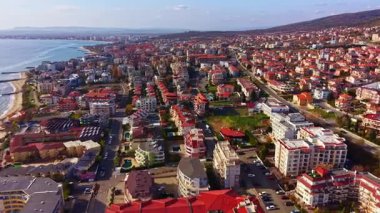 Parlak renkli çatılar güneş tepemizde ışıldarken canlı bir kıyı manzarasını işaret ediyor. Huzurlu okyanus hareketli caddelerin yanında parıldıyor hareketlilik ve hayat dolu.