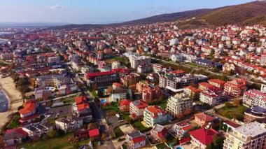 Renkli bir kasaba parlak bir gökyüzü altında yayılıyor, içinde büyüleyici kırmızı çatılı evler var. Yakınlardaki kumlu kıyılarda, deniz dalgalarının hafif dalgaları sakin yamaçlarla uyum içinde..