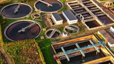 Kuş bakışı, su arıtma ve sürdürülebilirlik alanlarındaki kentsel çabaların vurgulandığı, dairesel tankları ve gelişmiş makineleri olan büyük bir su arıtma tesisi ortaya koyuyor..