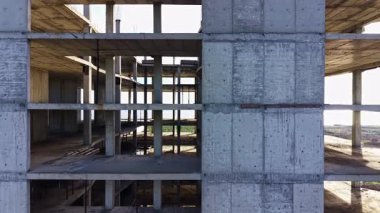 Bitmemiş beton bir binanın karmaşık detayları doğayla çevrili, alacakaranlığın ılık ışığıyla hafifçe aydınlatılmış, sessiz bir yalnızlık hissi uyandırıyor..