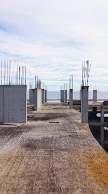 Paslı demirler, ıssız bir kıyı şeridi boyunca yıpranmış beton levhalardan yukarıya doğru uzanıyor. Uçsuz bucaksız okyanus, yumuşak bulutlu gökyüzünün altında ufukla buluşur. Durgunluk ve gizem hissi uyandırır..