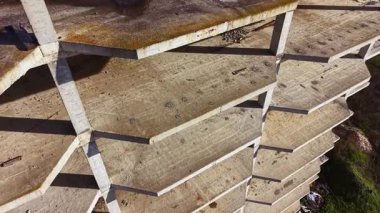 Bir zamanlar hareketli olan bir binanın kalıntıları gün batımına karşı çatlamış beton ve yıpranmış yüzeylerle yükseliyor. Doğa yavaşça mekanı geri alır, geçmişinden arta kalanları dokumaya başlar..