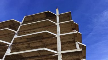 Beton iskelet, parlak mavi gökyüzüne karşı dimdik yükselir. İnşaatın saf güzelliğini ve kentsel bir manzarada gelecek gelişimi vaadini gözler önüne serer..