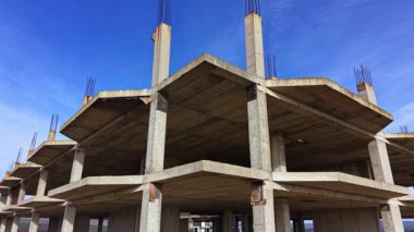 İnşaat alanında beton sütunlar, doğa ve kentsel gelişimin birleştiği canlı bir gökyüzünün altındaki gelecek bir binanın iskeletini gözler önüne sererek görkemli bir şekilde yükseliyor..