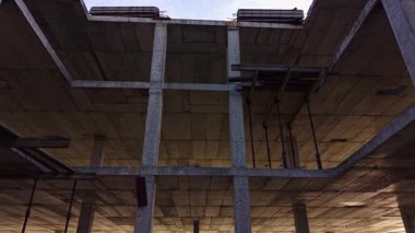 Aşağıdan bakıldığında, karanlık gökyüzüne karşı tamamlanmamış bir bina iskeleti görünür. Mimarinin saf güzelliğini ve yeni başlangıçların vaadini vurgular..