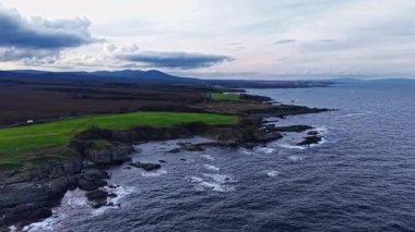 Yuvarlanan dalgalar kayalık kıyılara çarpıyor. Canlı yeşil alanlar kayalıklara yükseliyor. Manzara, sakin bir kıyı şeridi boyunca sakin bir gökyüzü altında sakin bir keşfe davet ediyor..