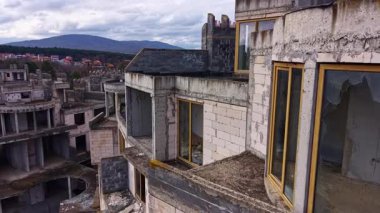 Yıkılan duvarlar ve parçalanmış pencereler, bu terk edilmiş yapıyı çevreleyen sakin dağların tam tersinde duruyor. Geçmişine dair merak ve nostalji uyandırıyor..