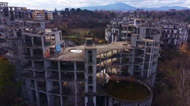 Çöken beton yapılar terk edilmiş bir gelişmede yükseliyor, doğa tarafından çevrelenmiş arazi geri alınıyor. Yukarıda bulutlu bir gökyüzü beliriyor, keşif için karamsar bir atmosfer yaratıyor..