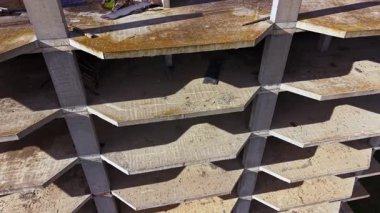 Terkedilmiş bir yapının boş zemininin üzerinde, güneş ışığı çatlakların arasından geçerken gölgeler beton yüzeylerde dans eder. Doğa, bir zamanlar hayat dolu olan şeyi geri almaya başlar..