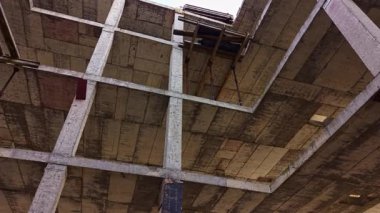 Unutulmuş bir binanın kalıntıları arasında, ışık boşluklardan süzülüyor, harap olmuş beton üzerinde büyüleyici desenler oluşturuyor..