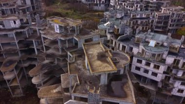 Aşırı büyümüş yeşilliklerin arasında paslanan yapılar, ihmalkarlığın ürkütücü çekiciliğini sergiliyor. Çökmüş duvarlar ve boş alanlar ıssız bir ortamda unutulmuş isteklerin hikayelerini anlatır..