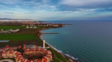Kıyı manzarası kıyı boyunca büyüleyici binalar barındırır. Alacakaranlıkta dalgalar yavaşça sahili sarar..