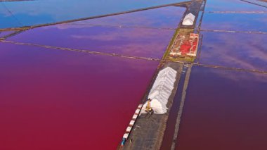 Göz alabildiğince parlak renkli tuz düzlükleri, pembe ve mavinin harmanlanmış gölgeleri. Kamyon çarpıcı manzaranın yanına park edilmiş, tuz toplamanın eşsiz güzelliğini vurguluyor..