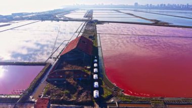 Güneşin sıcacık parıltısıyla pembe ve mavi gölcükler parıldıyor. Doğanın güzelliği arasında eski bir yapının yalnızlığını vurguluyor..