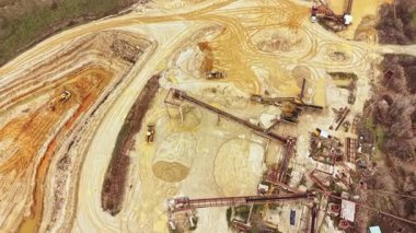 Makineler gelişmemiş bir yerdeki bir maden sahasında çalışıyor. Toprak, etrafa saçılmış toz ve aletlerden rahatsız oluyor. Bu sahne doğal ortamdaki endüstriyel aktiviteleri gösteriyor..