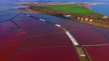 Nefes kesen bir manzara, yeşil tarlalar ve mavi suyla çevrili kırmızının gölgelerinde renkli tuz düzlüklerini sergiliyor. Gün batımında sakin bir ortamda doğanın güzelliğini yakalıyor..
