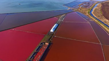Güneş sakin suların üzerinde batarken canlı kırmızı ve mavilerle zıt düşen tuzlu bataklıkları görselleştirmek, gözü ve ruhu büyüleyen sakin bir atmosfer yaratır..