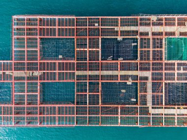 Yukarıdan büyük ahşap bir yapı görülür, suyun üzerine inşa edilmiş ve birkaç açık alan vardır. Yapı yapım aşamasında görünüyor. Gündüz vakti ve su mavi..