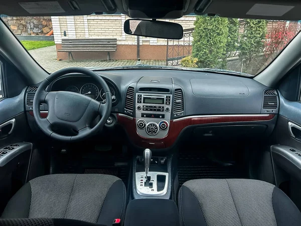 Arabanın içindeki görüntü gösterge paneli, direksiyon simidi ve vites kolunu gösteriyor. Güneş ışığı pencereden içeri giriyor ve ortam özel bir alan..