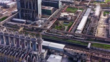 Büyük bir sanayi bölgesi birden fazla bina, boru ve depolama tankı gösteriyor. Bu ayar, olay yerinde konumlanmış ekipmanlarla aktif işlemleri gösterir.