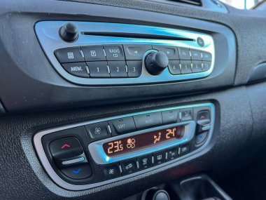 Aracın içinde radyo ve iklim ayarlarını gösteren bir kontrol paneli. Düğmeler ve kadranlar ses ve sıcaklığı ayarlamak için kullanılır.
