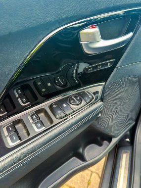 Sürücü tarafındaki kapıda pencere kontrolleri, kilit düğmeleri ve hoparlör var. Görüntü, güneş doğduğunda iç mekanın detaylarını yakalar..