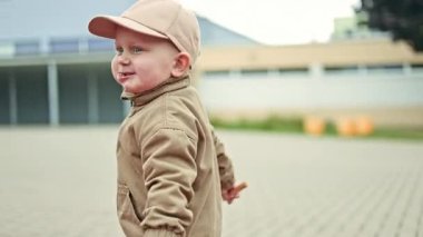 Gülümseyen mutlu çocuk 2 yaşında, parkta koşuyor. Çocuk sokakta yürürken oyun oynuyor ve koşuyor. Çocuk gelişimi.