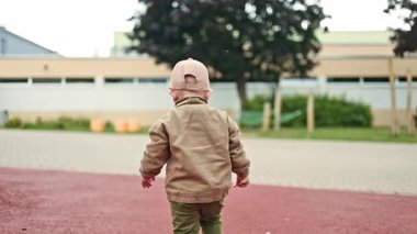 Gülümseyen mutlu çocuk 2 yaşında, parkta koşuyor. Çocuk sokakta yürürken oyun oynuyor ve koşuyor. Çocuk gelişimi.