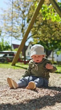 Yazın dışarıda çocukların oyun parkında oynayan tatlı küçük çocuk. Güneşli yaz gününde parkta yeşil çimlerde oynayan 2 yaşında bir çocuk. Doğadaki çocuklar için yaratıcı faaliyetler.