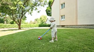 Yazın çocuk parkında oynayan komik küçük çocuk. Bebek parkta oynadıktan sonra dinleniyor. Mutlu bir çocukluk. Yazın parkta yürüyüş yapan bir çocuk..