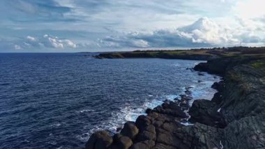 Batan güneşten gelen ışık engebeli kıyı şeridini öper, dalgalar yavaşça kıyıya vururken kayalara sıcak bir parıltı saçar. Doğanın güzelliği gözler önünde..
