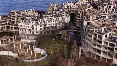 Bir zamanlar modern yaşamın bir görüntüsü olan bu ürkütücü kıyı şeridi, doğanın huzur dolu bir arkaplan ve gökyüzünün ortasındaki çökmekte olan betonu yavaş yavaş geri aldığı yerde çürümekte..