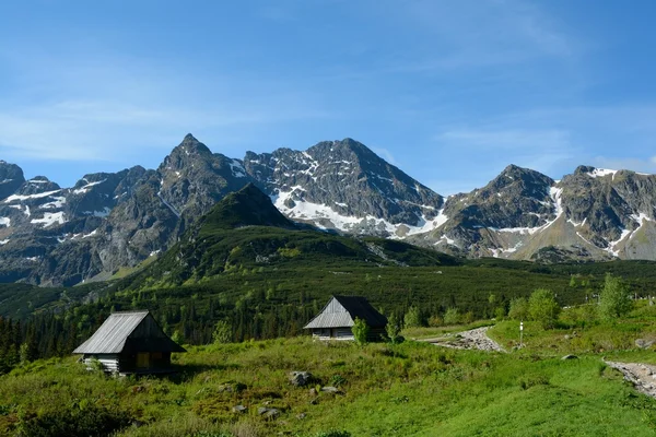 Two old wooden small huts and peaks in Gasienicowa valley — Stock Photo, Image