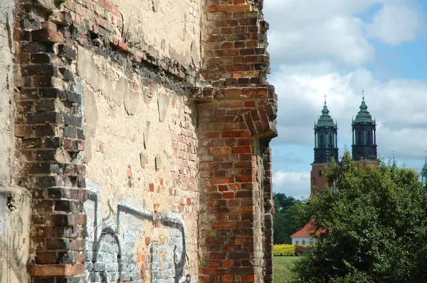 Antiguo edificio en ruinas pared de ladrillo y torres de la iglesia —  Fotos de Stock