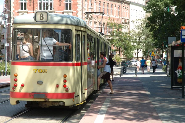 Lidé dostat na a z tramvaje v Poznani, Polsko. — Stock fotografie