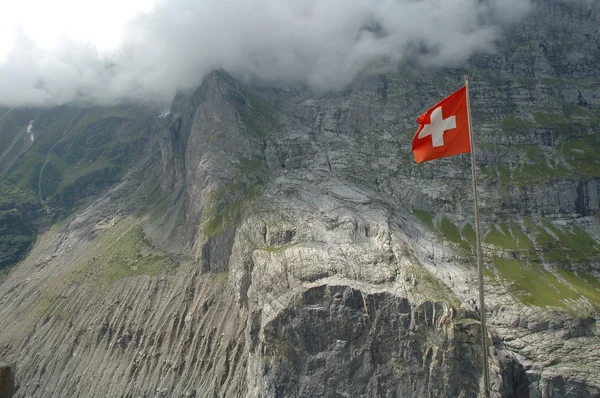 Swiss flag high in mountains nearby Grindelwald in Switzerland. — Stock Photo, Image