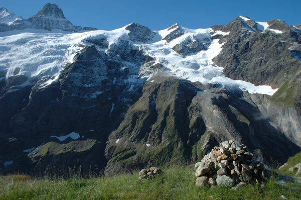 Cairn and peaks in snow nearby Grindelwald in Switzerland — Stock Photo, Image