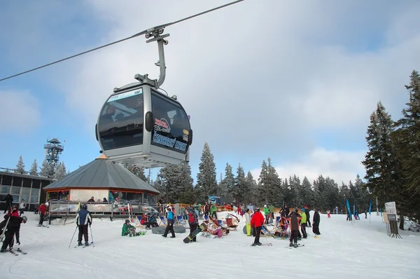 Teleférico, restaurante y esquiadores . Fotos De Stock