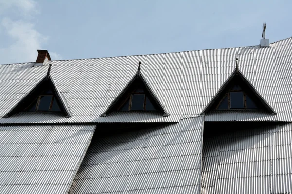 Απότομη στέγη καλυμμένη με ασημένια κυματοειδή πλάκες. — Φωτογραφία Αρχείου