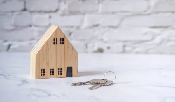 Miniatur Holzhaus Mit Schlüssel Auf Weißem Ziegelboden Versicherungen Hypotheken Handel — Stockfoto