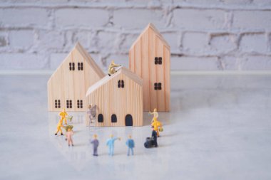 Mühendisler ve mimari minyatür işçileri mavi arka planda ev inşaatına ve onarımına yardım ediyor. Takımın iş ve emlak konsepti kopya alanı ile birlikte..